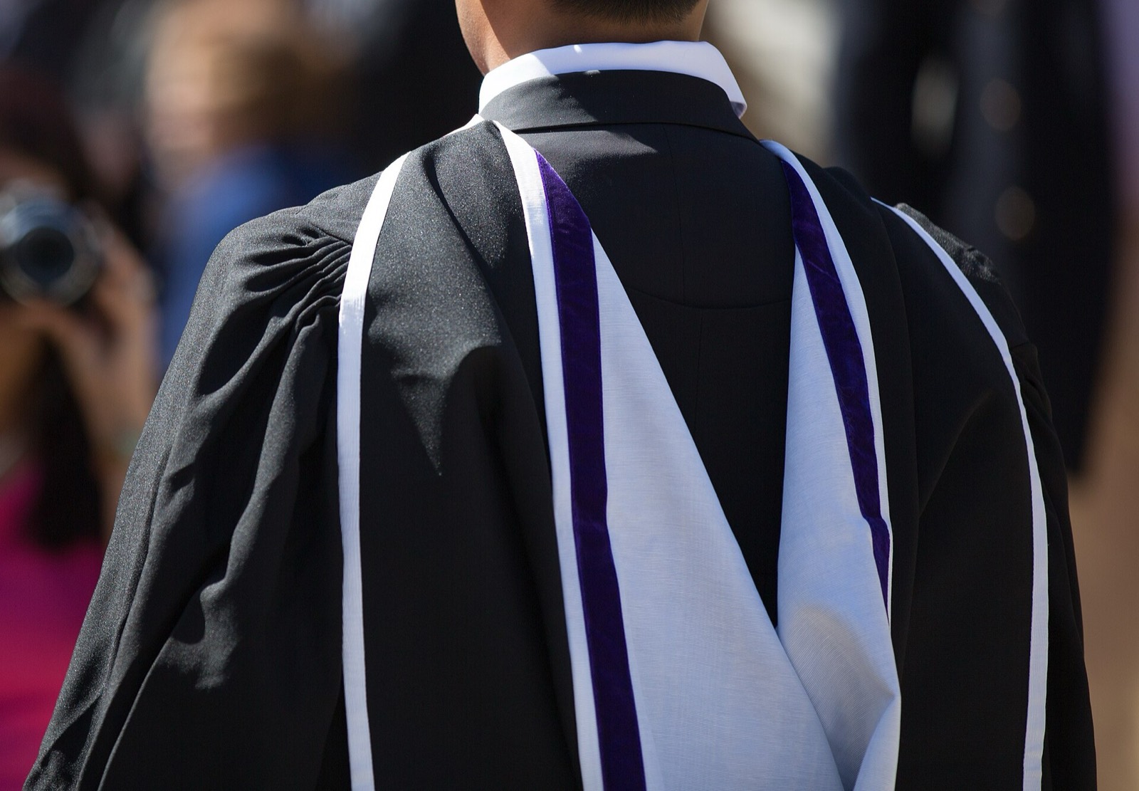 A graduate in academic dress being photographed